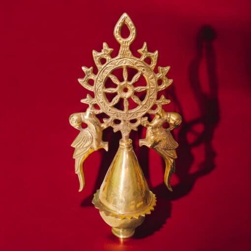 Brass Nilachakra Gopuram displayed on a puja room altar, creating a devotional atmosphere.